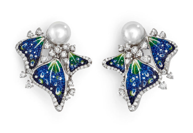 Butterfly-shaped earrings with blue and green details and pearl centers on a white background