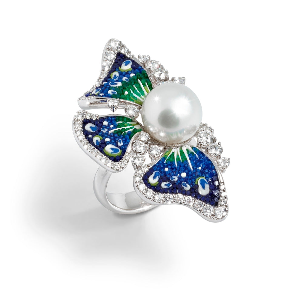 Butterfly-shaped ring with a pearl center on a white background