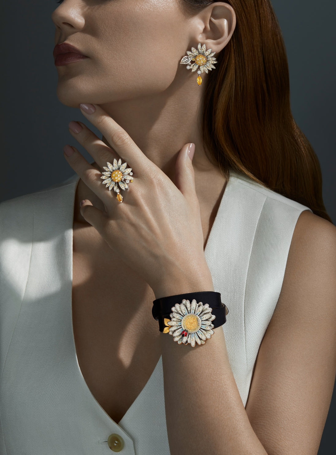 Woman wearing flower-themed earrings and bracelet against a dark background