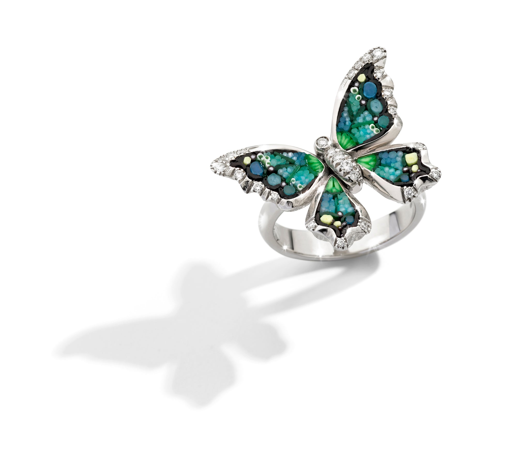 Butterfly-shaped ring with gemstones on a white background