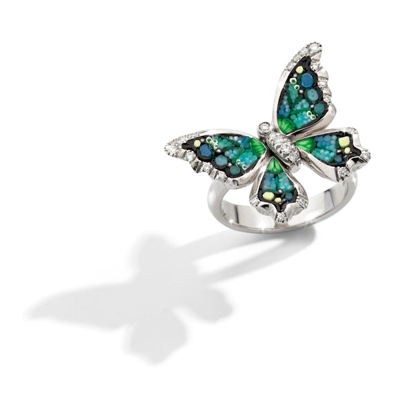 Butterfly-shaped ring with gemstones on a white background