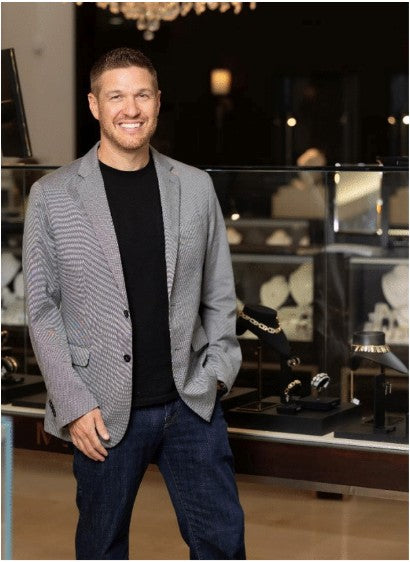 Professional photograph of Seth Berman standing in front of luxury jewelry case.