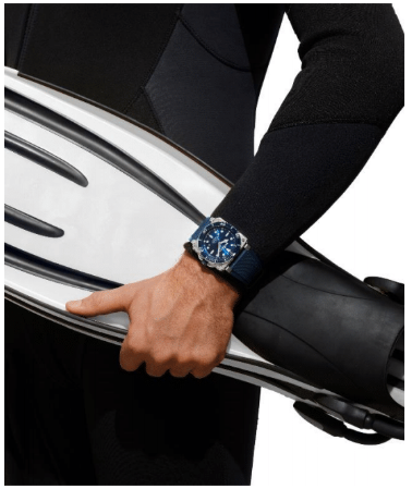 Lifestyle Image- Male diver wearing scuba gear, carrying fins and wearing diver blue steel watch