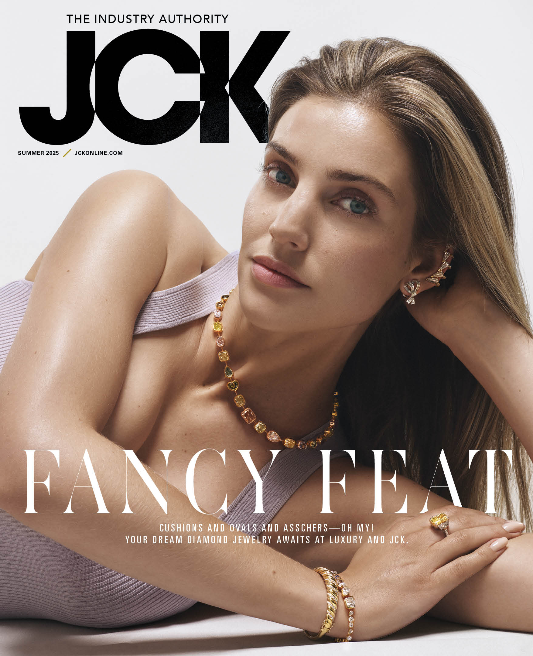 Professional cover photograph of JCK Online showing a brunette woman wearing multi-colored gemstone necklace, bracelet, earrings, and ring.