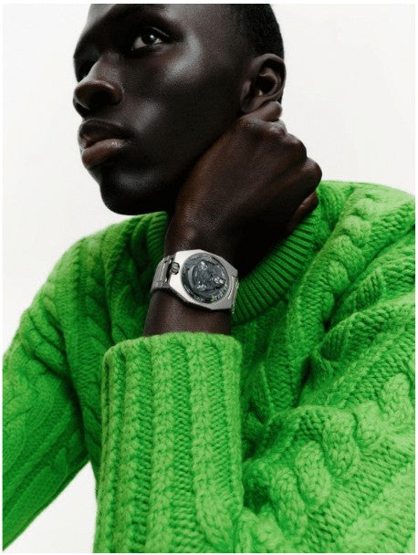 Lifestyle Image of URWERK UR - 100V Magic T “Hunter Green”. Picture of a man in lime green sweater displaying watch on his wrist.