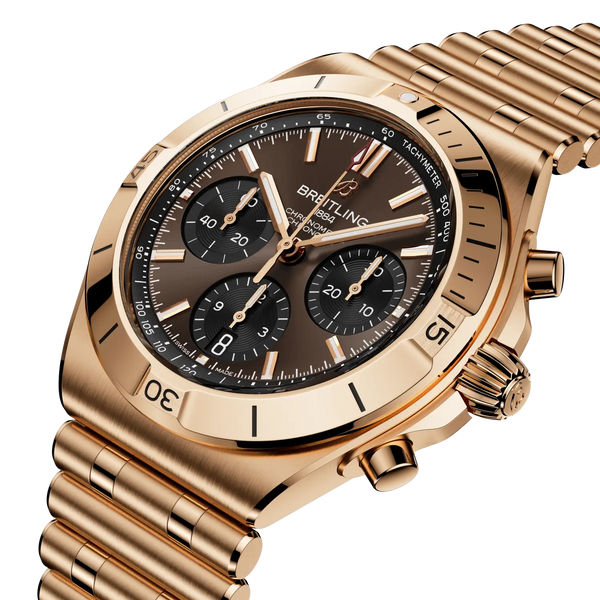 Gold wristwatch with a detailed face on a white background