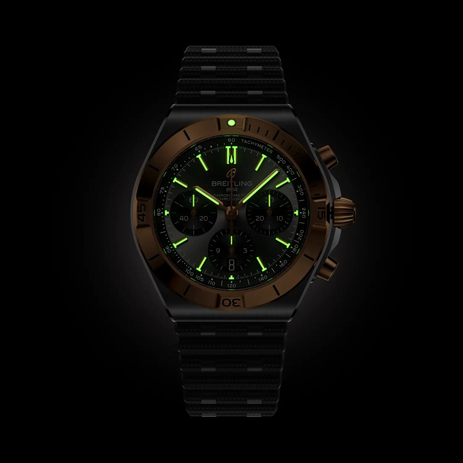 Breitling watch with green glowing face on a black background